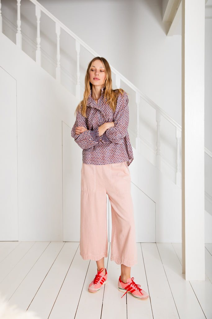 A model wears Bonte's patterned purple top and pink wide-leg pants, paired with red and pink sneakers.