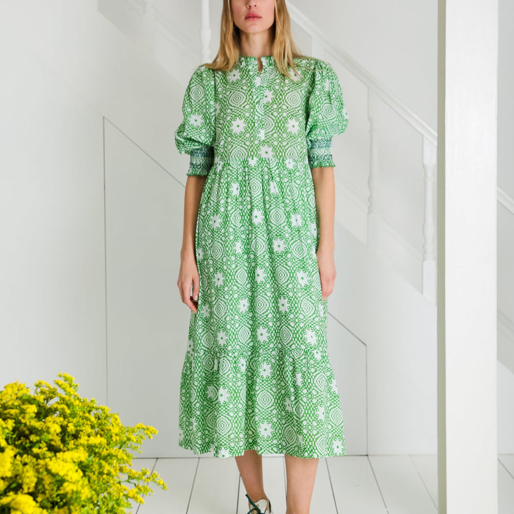 Model wearing a green patterned dress by Bonte with white floral details, styled with a minimalist background.