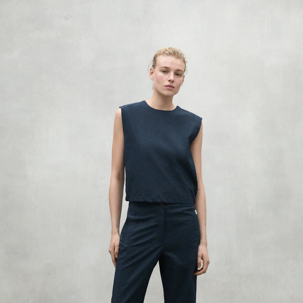 Model wearing a navy sleeveless top and matching pants by Ecoalf, against a light grey background.