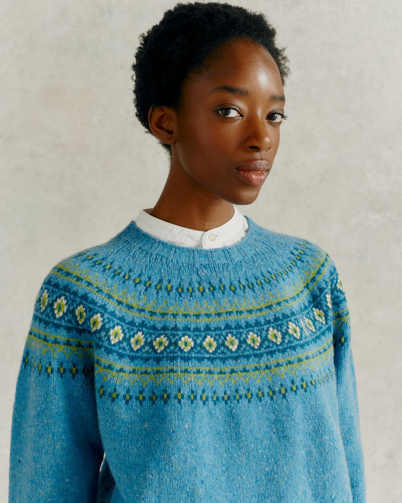 headshot of a female model, wearing white linen trousers and a Harley of Scotland Fairisle Jumper - Coll